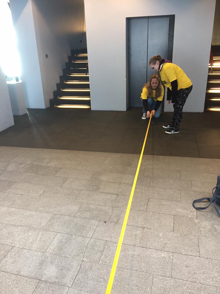 Participans marking stairs with yellow tape