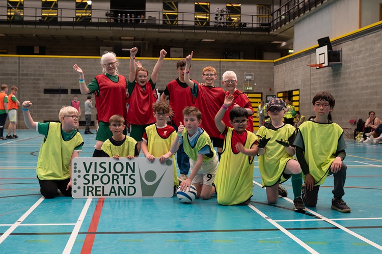 a group of 12 young participants after competing in their football blitz holding a VSI sign